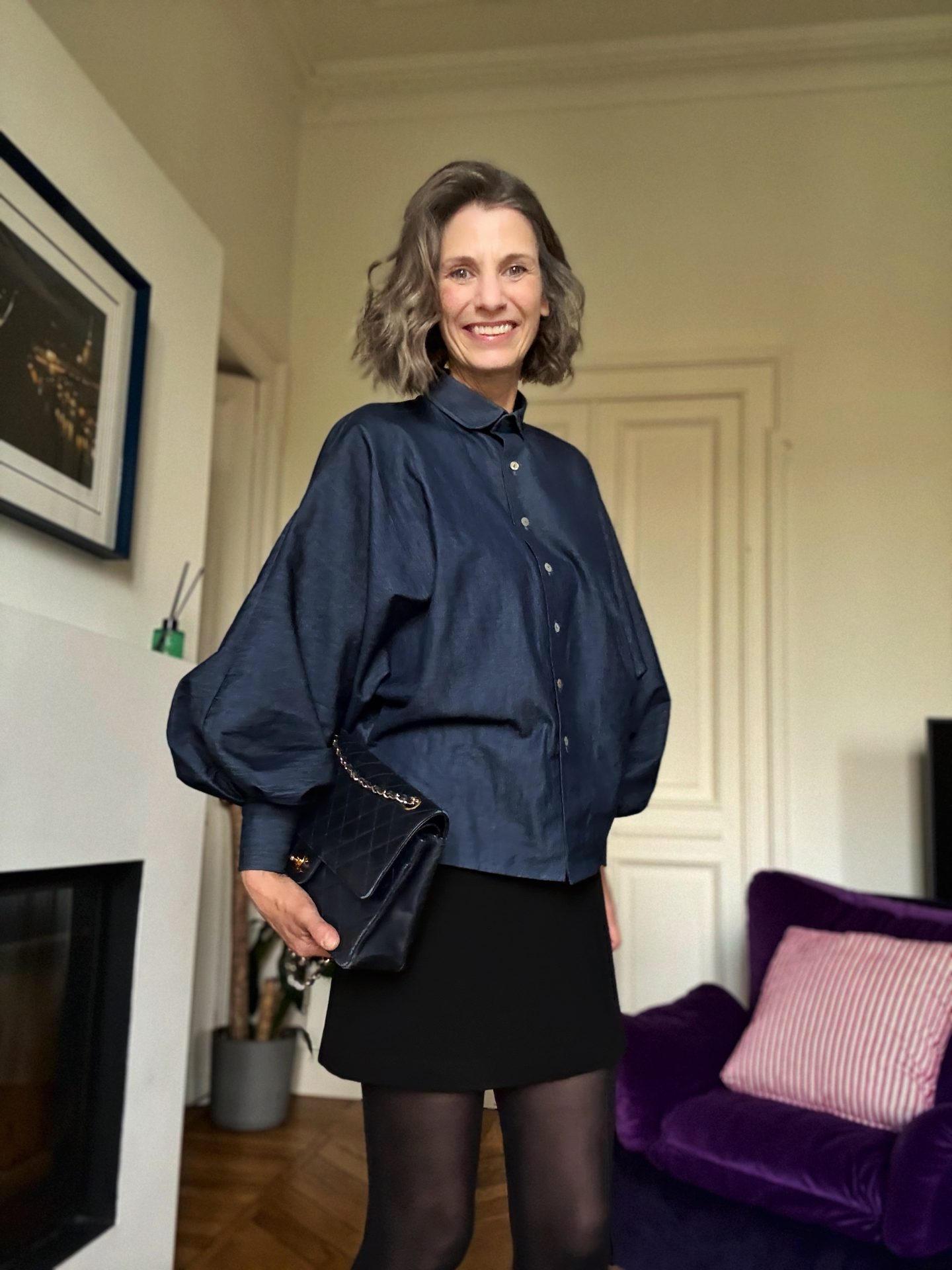 Outfit con minigonna Armani e camicia denim Marie, abbinato a calze coprenti, stringate maschili e borsa Chanel vintage