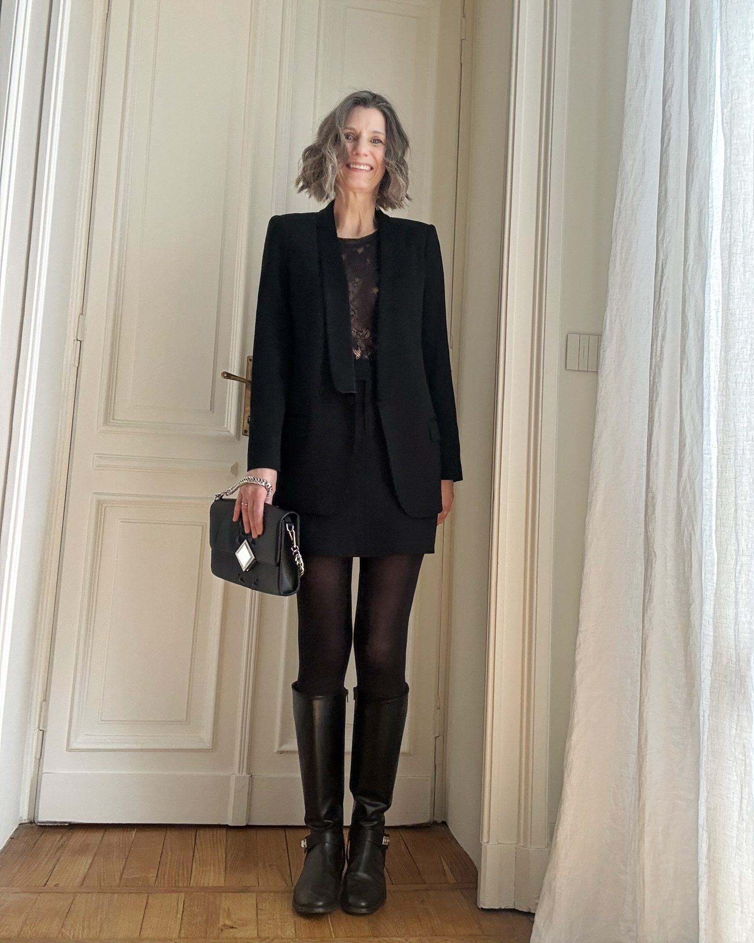 outfit con minigonna nera, giacca smoking e stivali cavallerizza in pelle