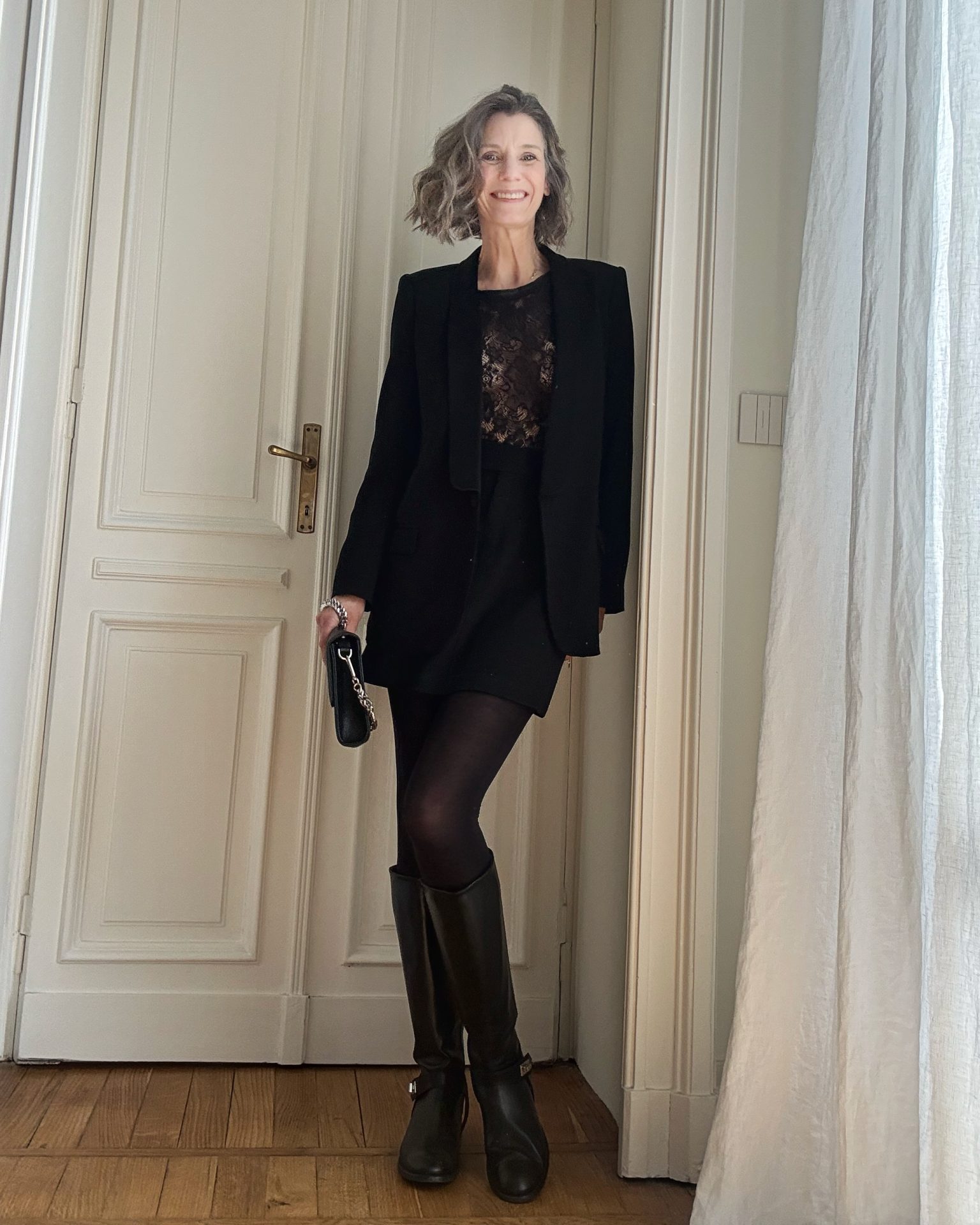 Look elegante con minigonna nera e blazer smoking abbinato a stivali cavallerizza