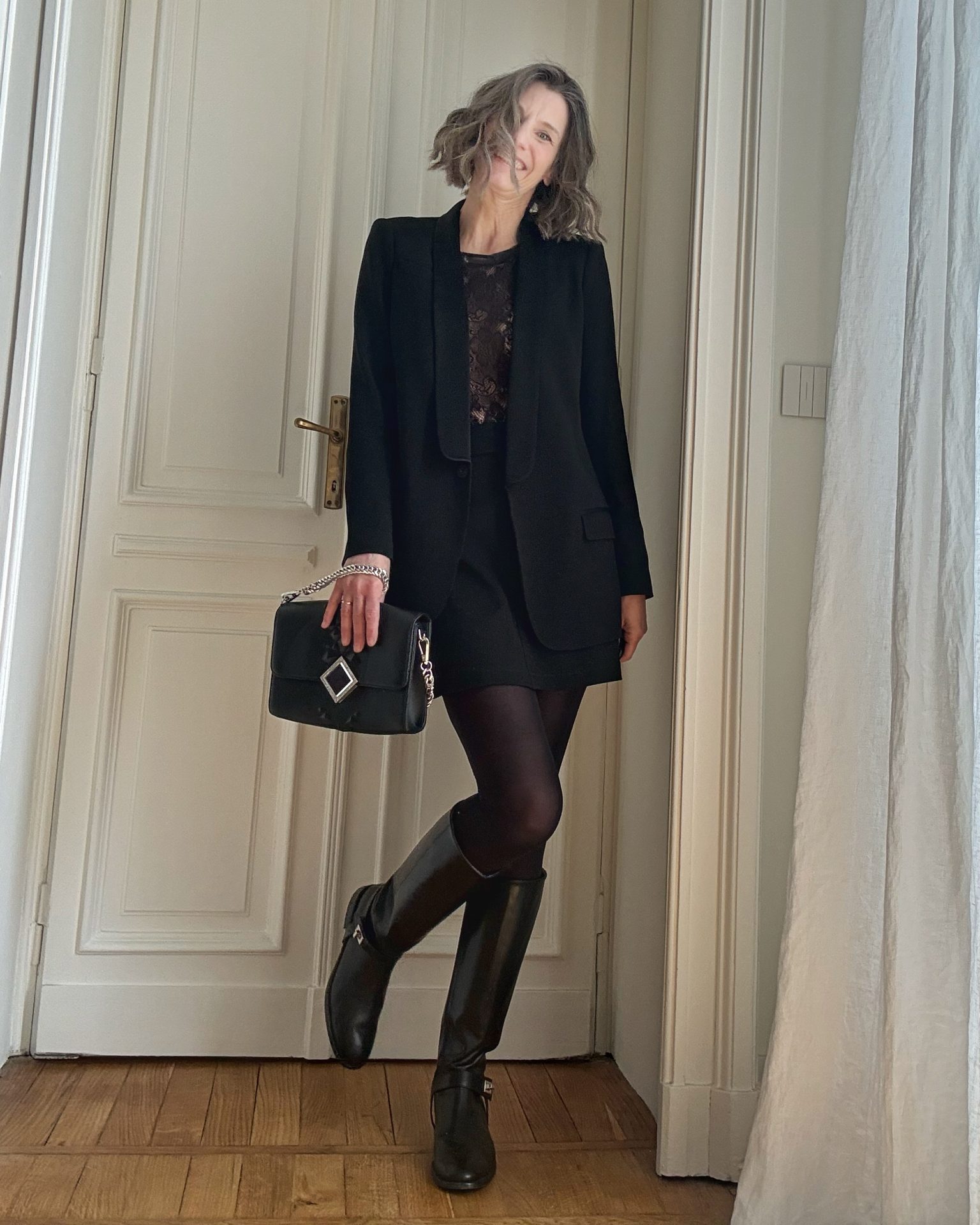 Abbinamento con minigonna nera, giacca stile smoking e stivali alti in pelle modello cavallerizza